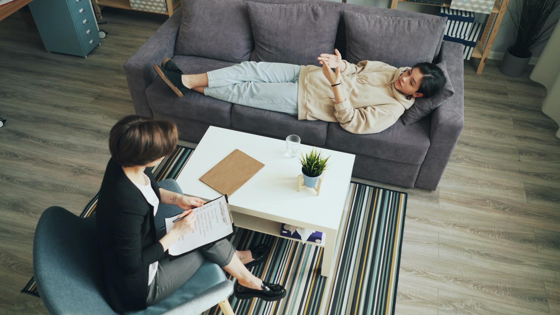a woman is sitting on a couch with a man on the floor